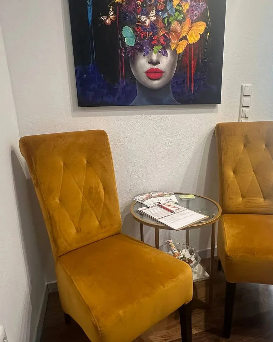 Wartebereich im Studio Hautverliebt mit zwei Sesseln und Kunstdruck an der Wand.